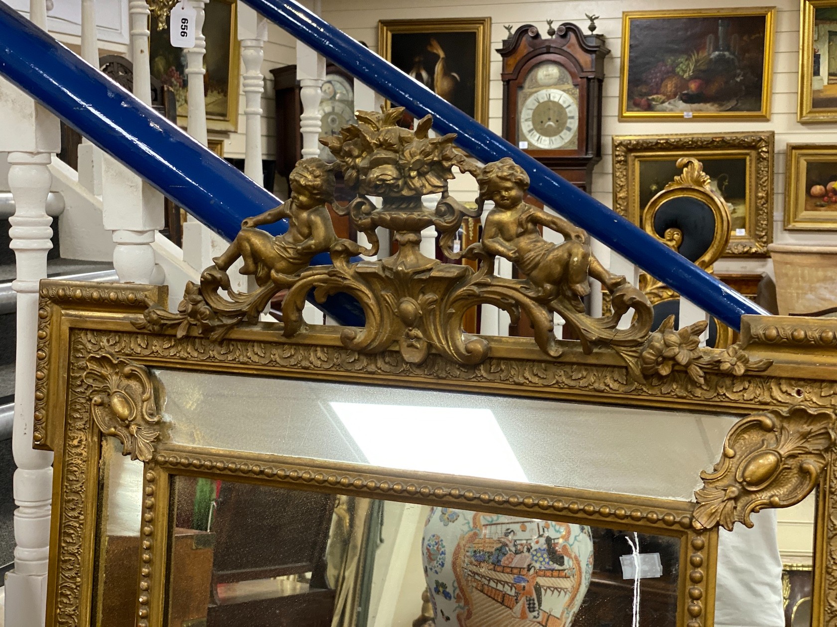 A French giltwood and composition overmantel mirror with floral cherub pediment width 91cm, height 157cm.